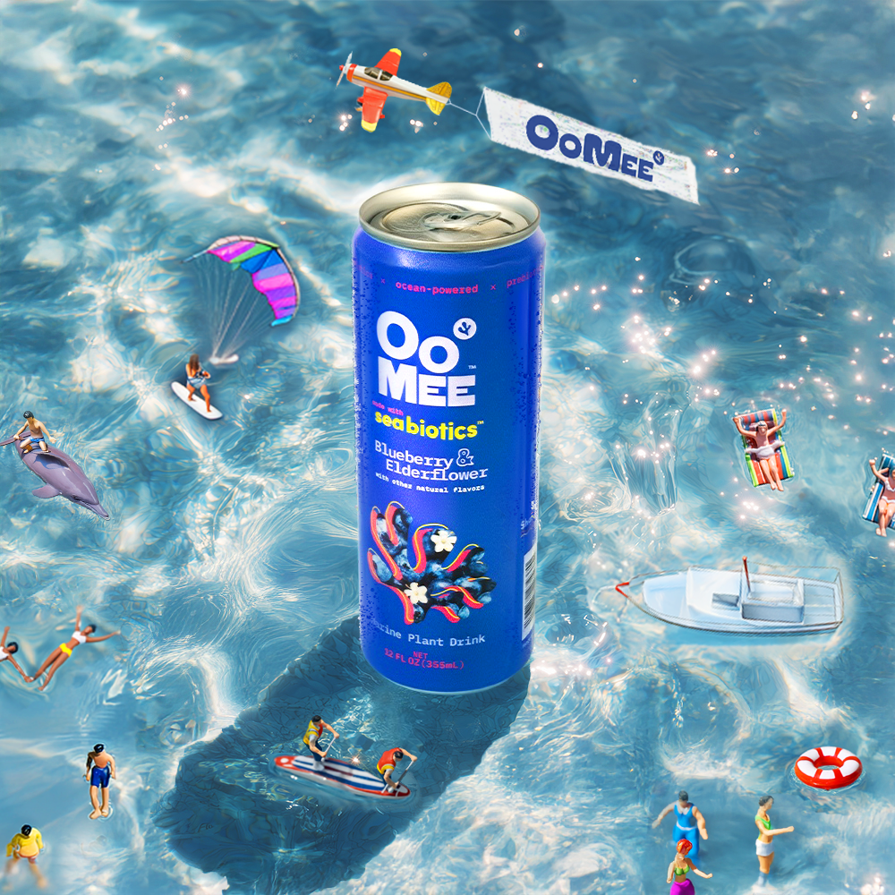 Blueberry & Elderflower OoMee Marine Plant Drink can floating in a sparkling ocean with playful mini beachgoers, surfers, swimmers, and a plane flying a banner that says “OoMee.”