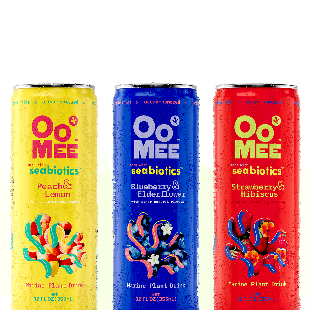 Three colorful OoMee marine plant drink cans—Peach & Lemon (yellow), Blueberry & Elderflower (blue), and Strawberry & Hibiscus (red)—standing upright with water droplets against a soft white and pale green background.